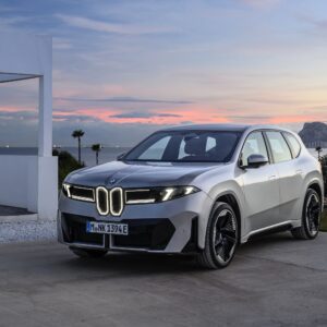 A BMW iX3 at sunset with Gibraltar in the background