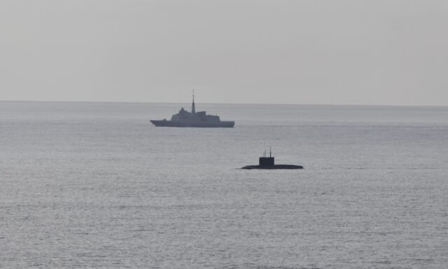 A French Navy vessel watches the surfaced Russian sub Novorossiysk this week.