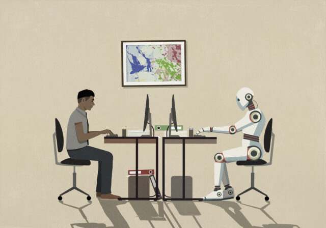 Man and humanoid robot working face to face at computers
