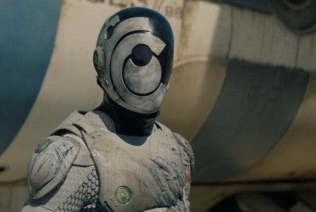 shot of head and upper torso of white armored robot and a faceless mask