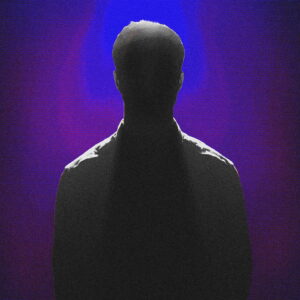 Silhouette of a man against a dimly lit backtround