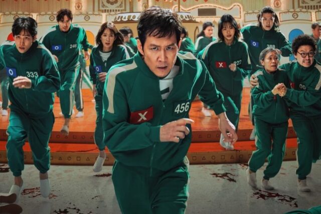 assembly of asian people in matching jumpsuits preparing to compete in a deadly game