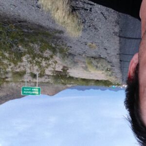 Avellone stands in front of a road sign on a highway